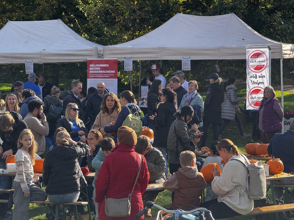 Bild mit vielen Menschen auf einem Spielplatz bei der Kürbisschnitz-Aktion der Köricker Buben